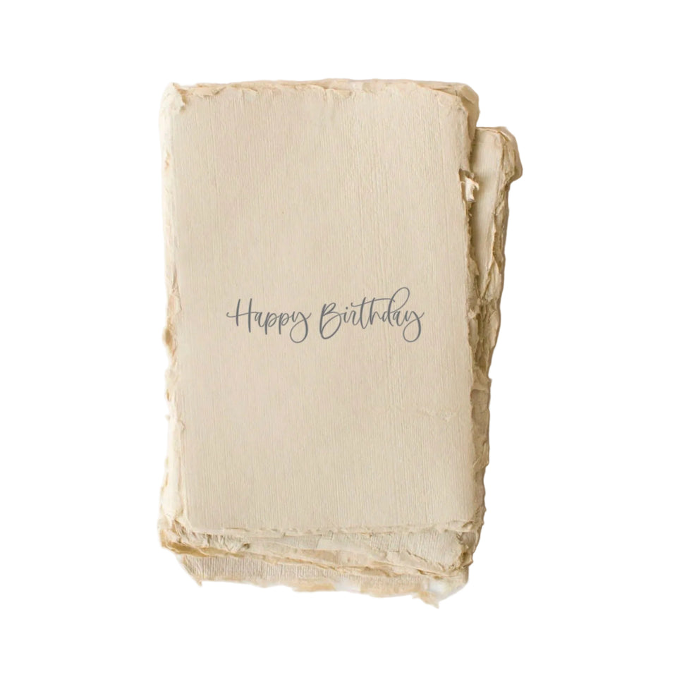 Happy Birthday greeting card with handwritten script text on cream textured paper with raw edges