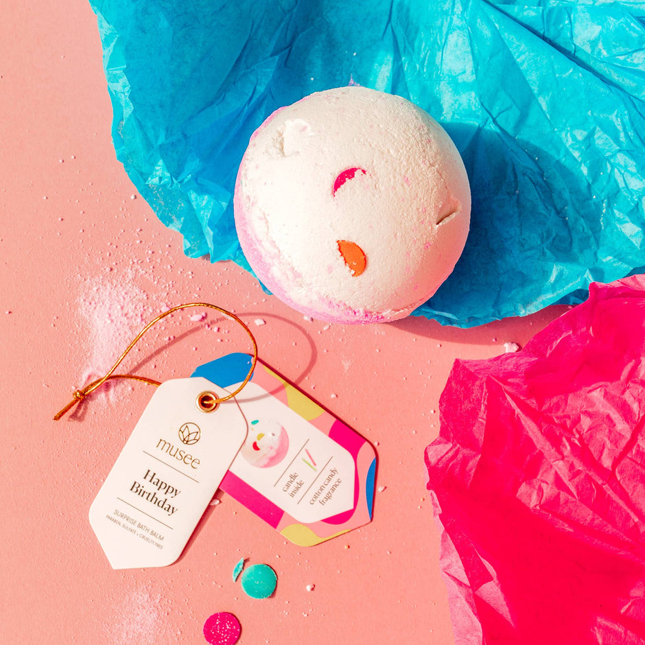 Bath bomb with colorful tags on a pink surface