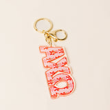 Red floral acrylic sorority letter keychain with gold key rings on neutral background
