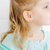 Child wearing Madison Pink screwback stud earrings by LINNY CO, styled with green striped top