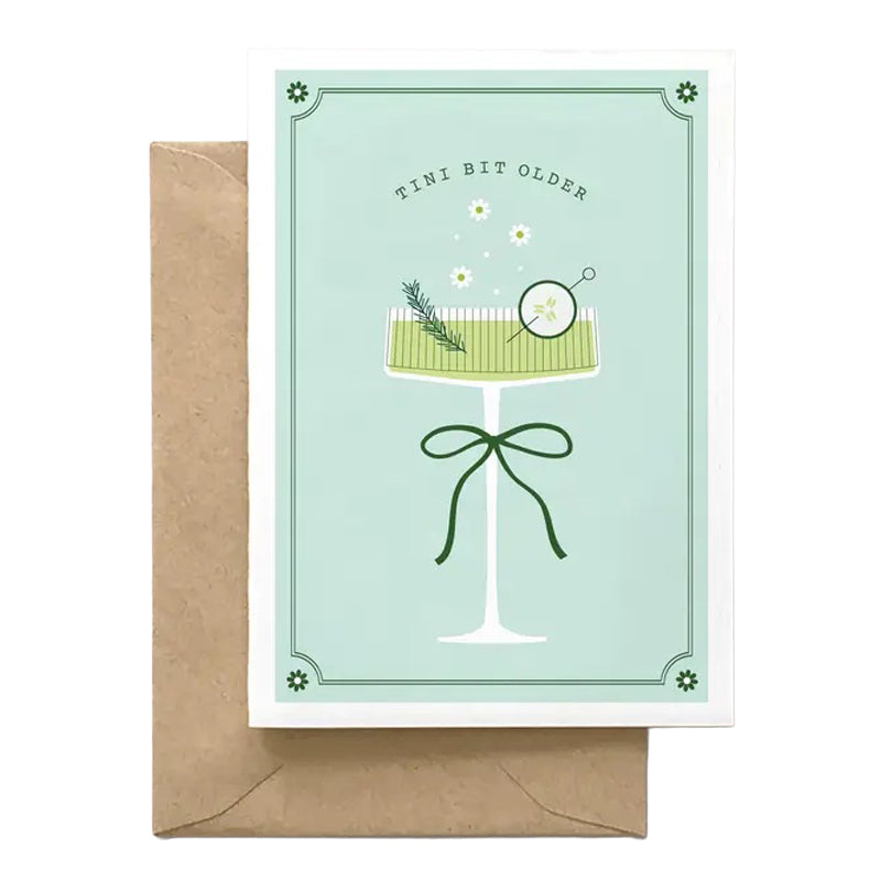 Greeting card with a cocktail illustration and text, accompanied by a brown envelope on a white background.