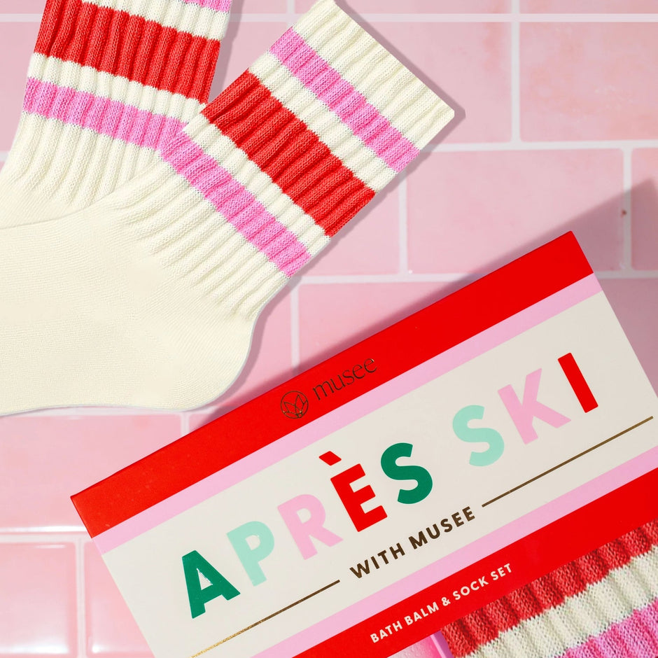 Après ski bath balm and sock set on a pink tiled background