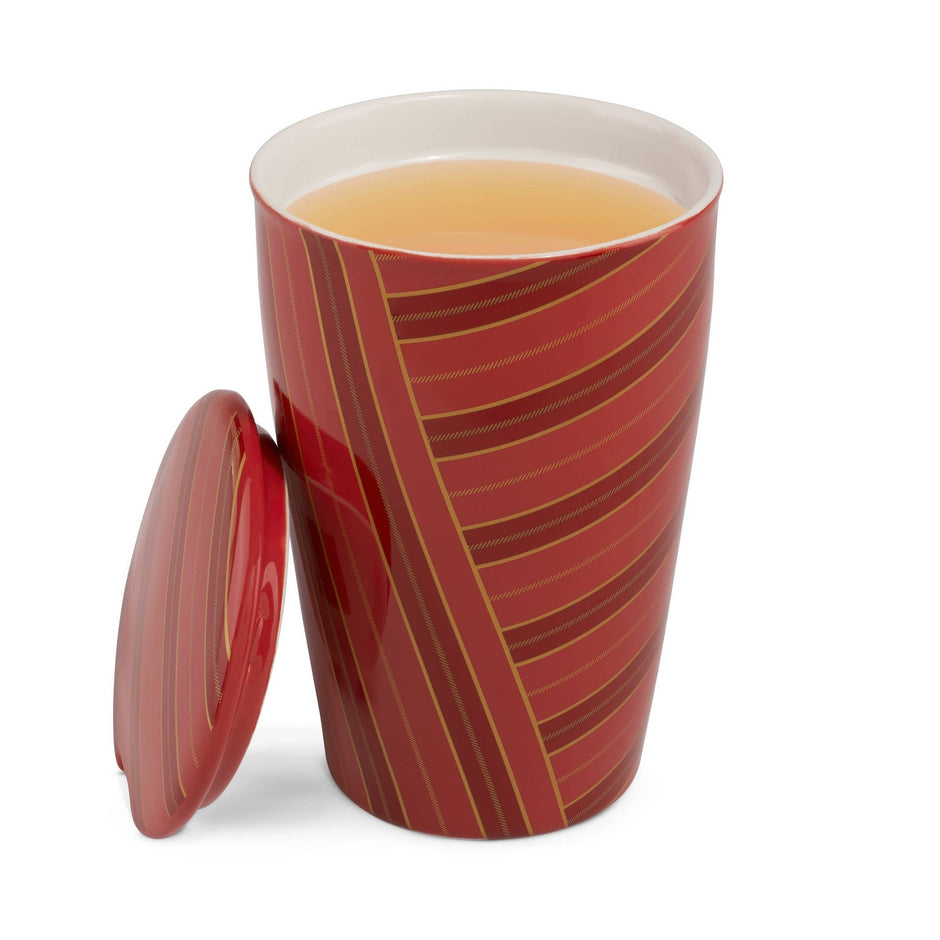 Tea Forte Warming Joy KATI Cup with red and gold striped design and matching lid, filled with tea