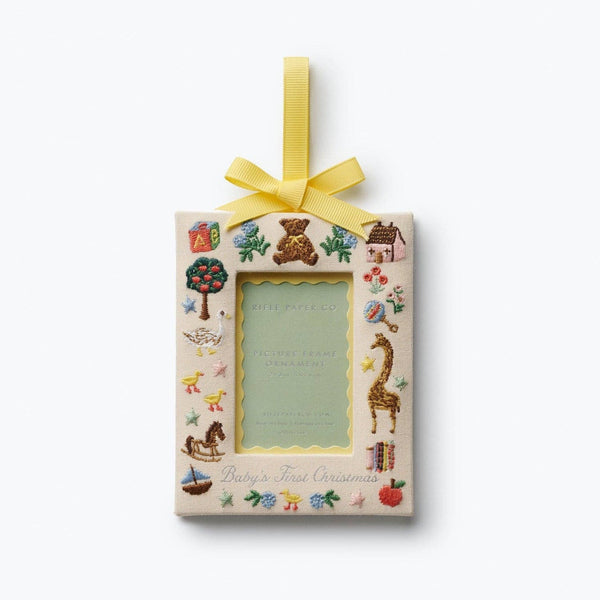 Rifle Paper Co. Baby's First Christmas picture frame ornament with embroidered toys and yellow ribbon