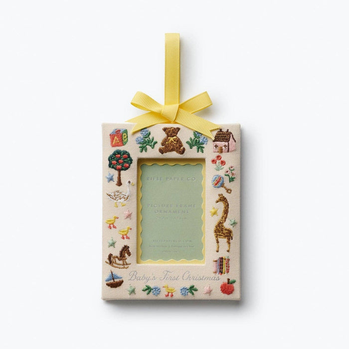 Rifle Paper Co. Baby's First Christmas picture frame ornament with embroidered toys and yellow ribbon