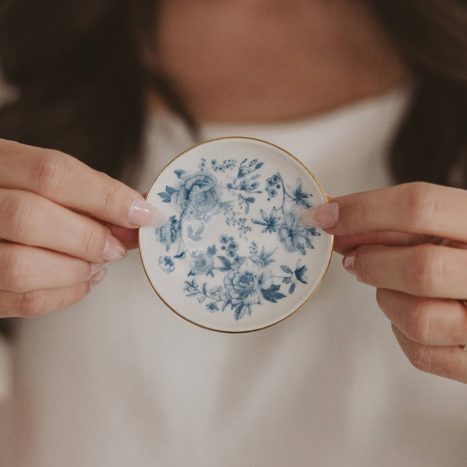 Blue Delft jewelry dish held in hands, displaying intricate floral ceramic design
