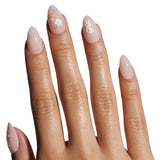 Close-up of a hand with pink nail polish and floral designs on a white background