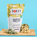POPPY hand-crafted caramelized onion and sage popcorn displayed with fresh sage and popcorn in a bowl
