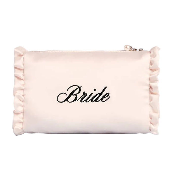 Cream satin cosmetic bag with 'Bride' embroidery and pink ruffled edges on blue background