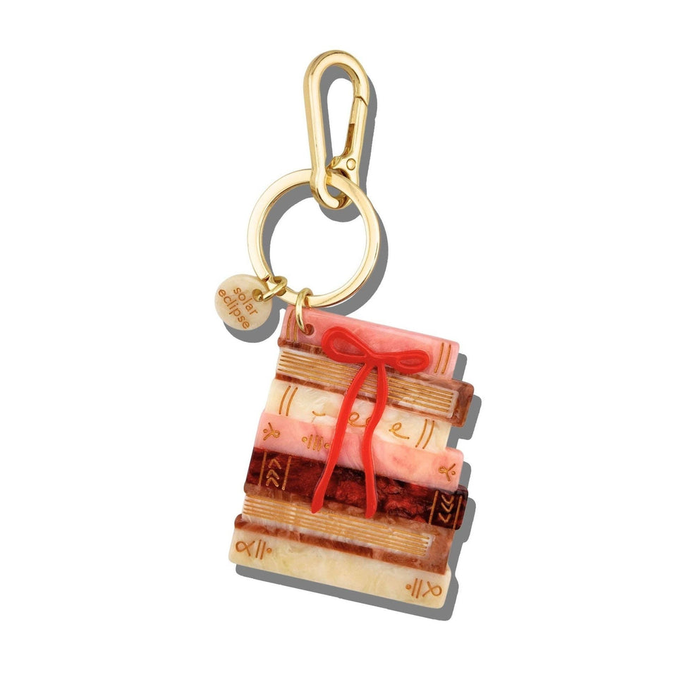 Hand-painted bow bookstack bag charm with stacked colorful books and red bow, gold keychain clip