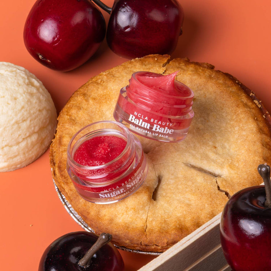 NCLA Beauty Apple Pie Mini Lip Care Set with red lip balms displayed on pie with fresh cherries