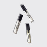 Three Kitsch hair perfume bottles with black caps arranged on white background