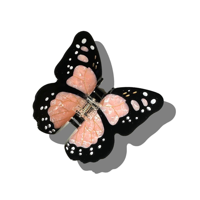 Solar Eclipse hand-painted monarch butterfly claw hair clip with black wings and pink details on white background