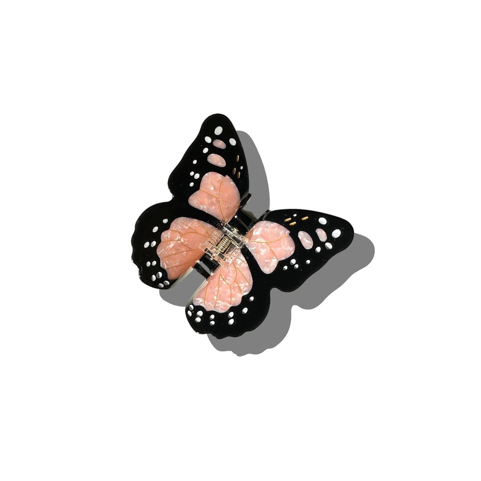 Solar Eclipse hand-painted monarch butterfly claw hair clip with black wings and pink details on white background