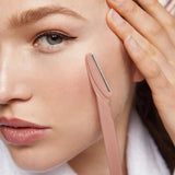 Woman using a pink skincare tool on her face
