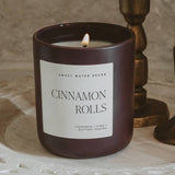 Cinnamon Rolls scented soy candle in matte jar with lit flame and bronze decor