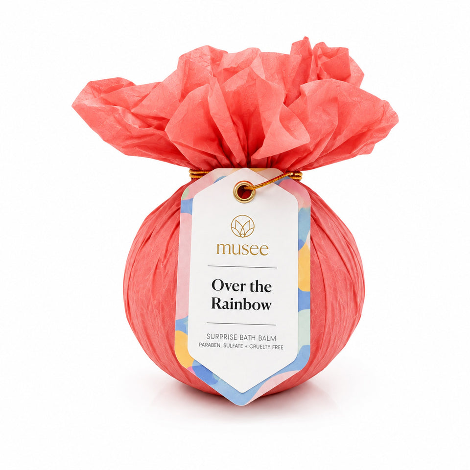 Musee Over the Rainbow surprise bath balm wrapped in coral tissue paper with colorful tag