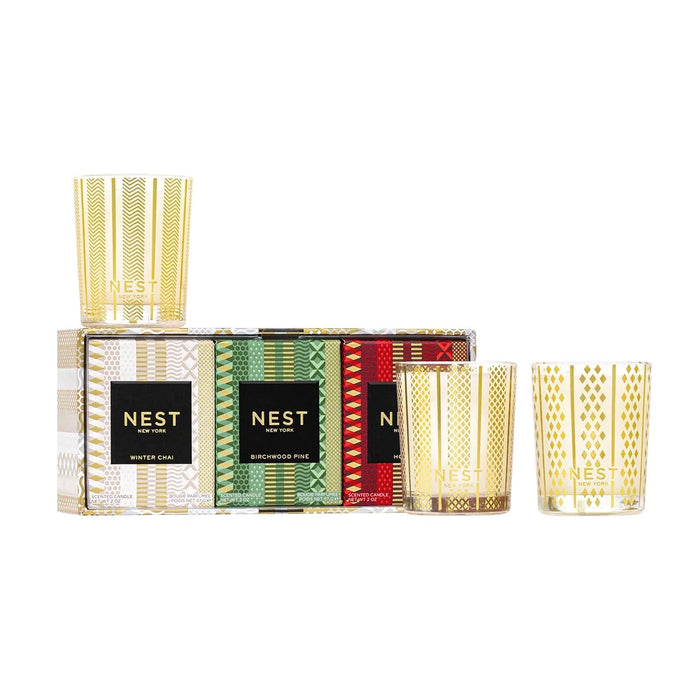 NEST New York Holiday, Birchwood Pine and Winter Chai votive candle trio, three glass votives beside their gift box on a white background