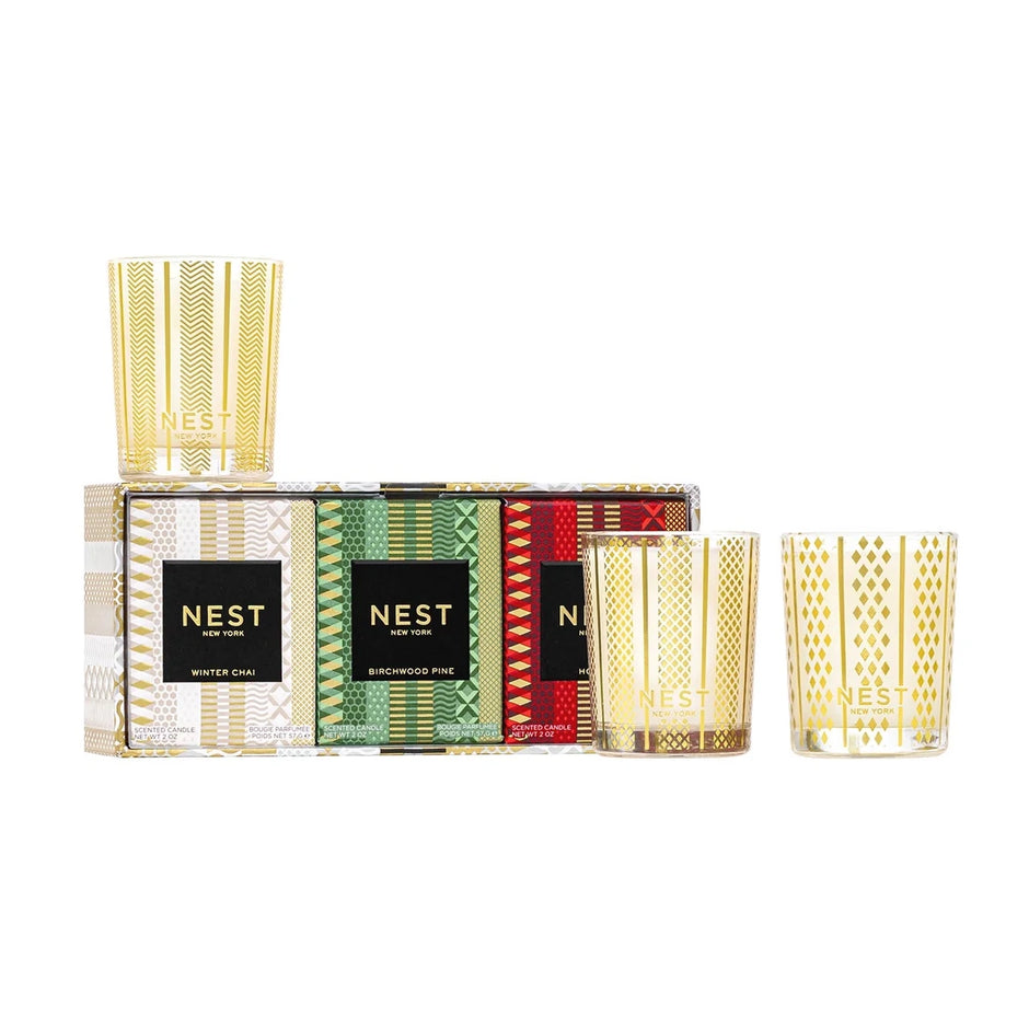 NEST New York Holiday, Birchwood Pine and Winter Chai votive candle trio, three glass votives beside their gift box on a white background