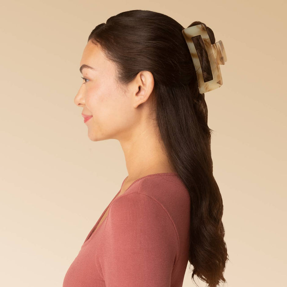 Chocolate marble jumbo claw clip worn in long dark hair on model wearing burgundy top