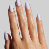 Model wearing Sky short almond press-on nails in white, showing manicure on hand against gray background