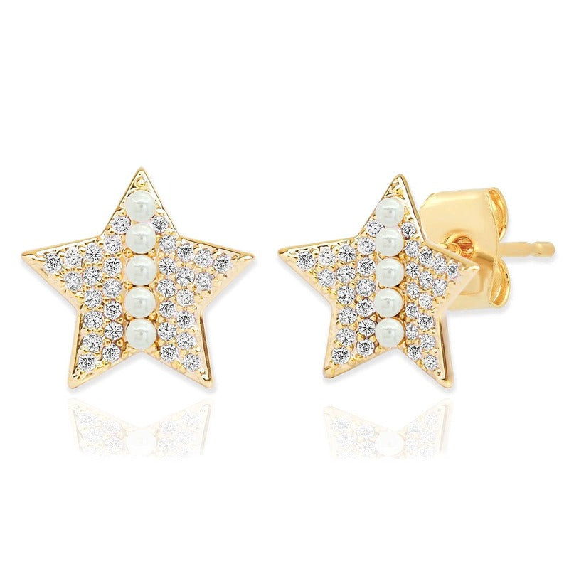Gold star stud earrings with pavé diamonds and pearl line detail on white background