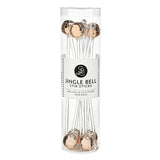 A clear cylindrical package containing rose gold jingle bells stir sticks, with a white label reading 'JINGLE BELL STIR STICKS' and 'INCLUDES 8 STIR STICKS ROSE GOLD'.