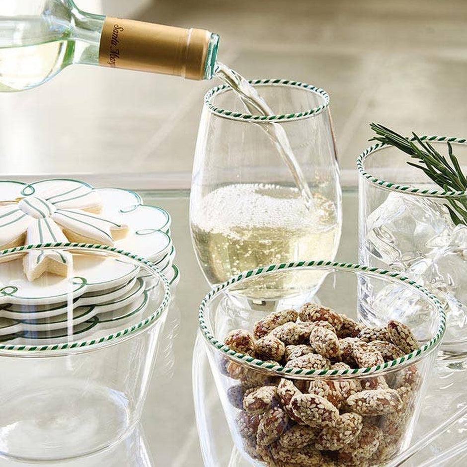 Peppermint Twist wine poured into striped glasses with snacks and rosemary garnish at a table setting