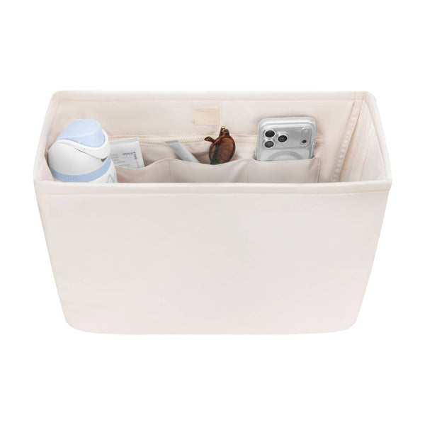 Beige fabric tote organizer with compartments containing phone, sunglasses, and accessories