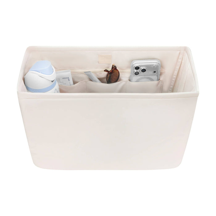 Beige fabric tote organizer with compartments containing phone, sunglasses, and accessories