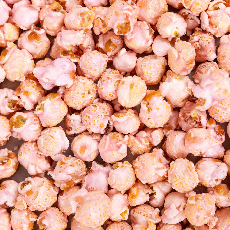 Pink Shirley Temple popcorn with caramel coating and gold sprinkles, close-up overhead view