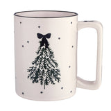 Cream ceramic holiday mug with black Christmas tree design, bow topper, and scattered stars