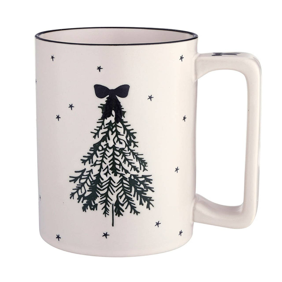 Cream ceramic holiday mug with black Christmas tree design, bow topper, and scattered stars