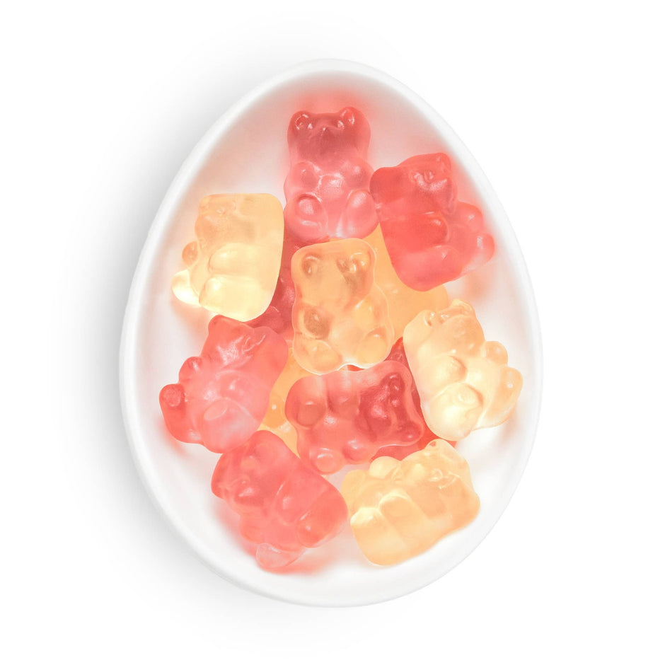 Sugarfina Champagne Bears gummy candies in red and gold colors in white oval dish