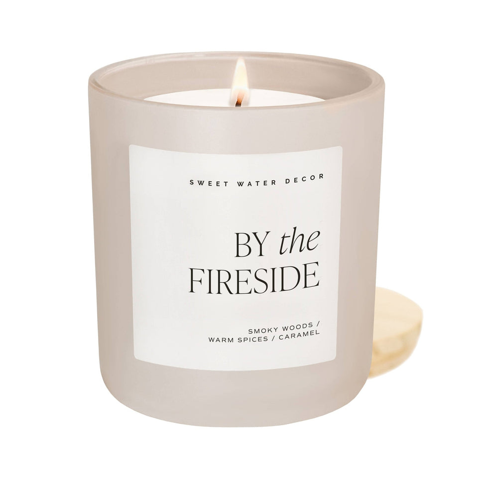 Sweet Water Decor By the Fireside 15oz soy candle in matte beige jar with lit flame