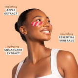 Woman with pink eye masks on a beige background with text about skincare ingredients.