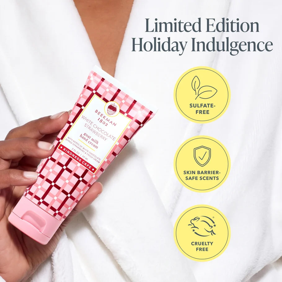Hand holding the White Chocolate Strawberry hand cream tube with sulfate-free, skin barrier-safe scents and cruelty-free badges