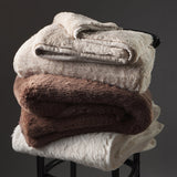 stack of folded blankets on a chair