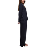 Model wearing the Ultra Soft Rib sleep shirt and pant in Black with white piping, side view