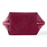 KUSSHI | Vacationer Makeup Bag — Wine/Zebra, The bottom of a burgundy leather bag with gold-tone zippers on the sides and a geometric stitched design on the bottom.
