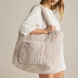 woman holding blanket bag over her shoulder