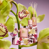 Cosmetic products with orchids on a purple background