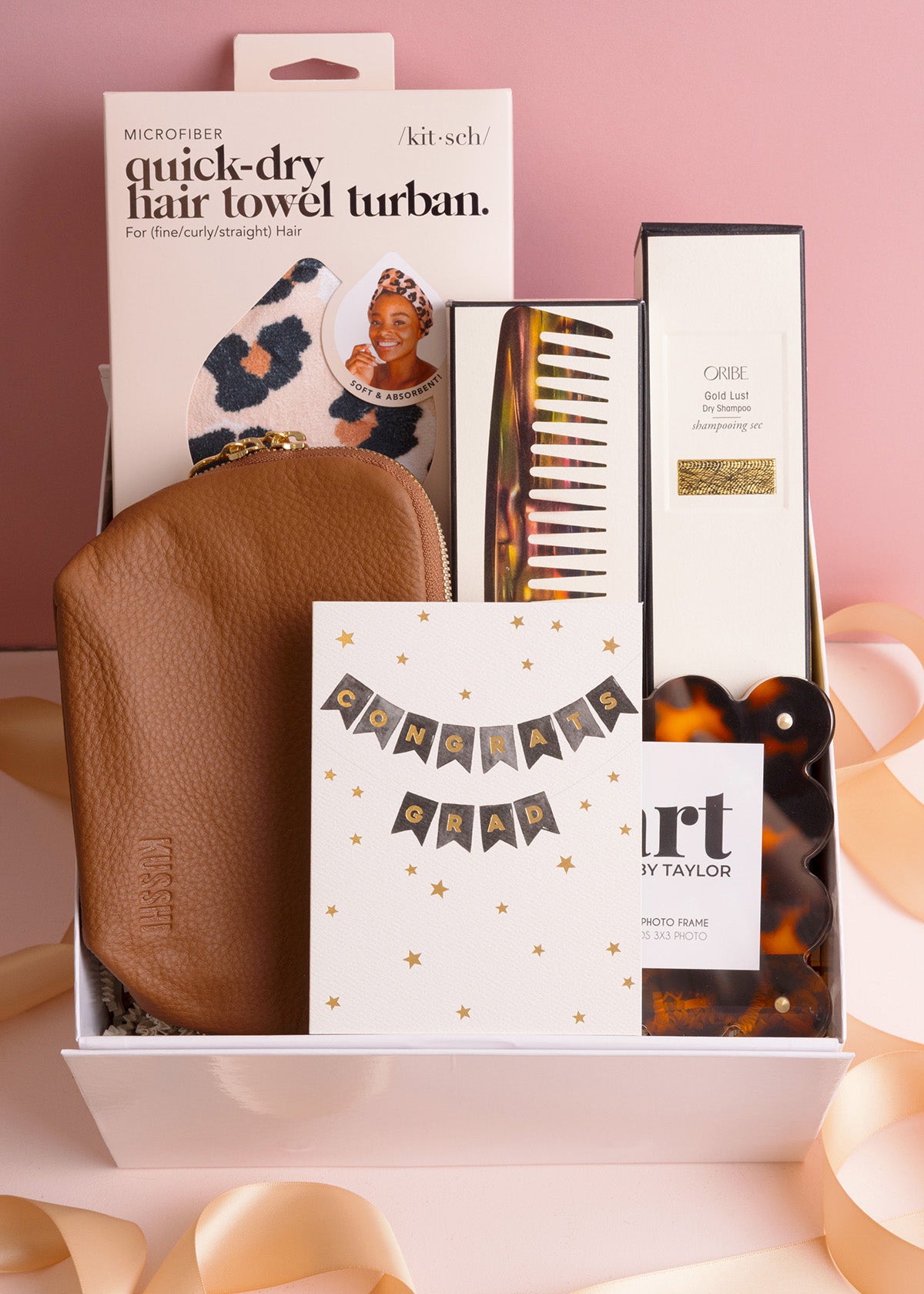 Gift box with hair care products and accessories on a pink background