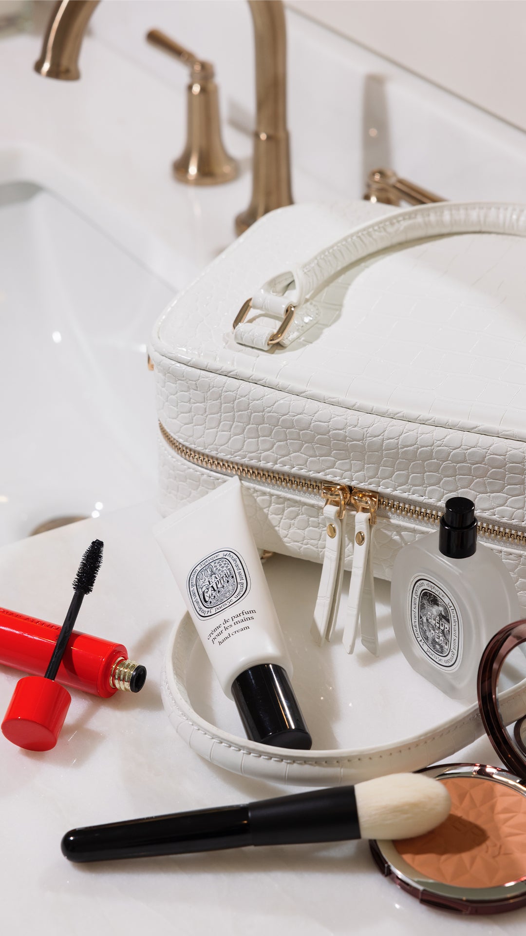 White cosmetic bag with makeup items on a white surface