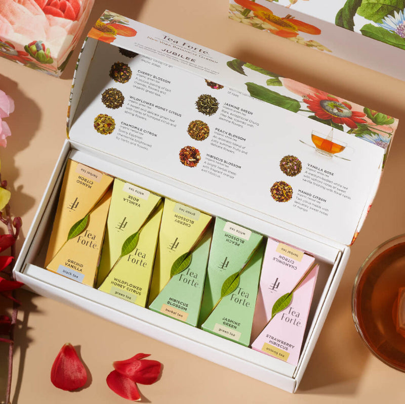 Jubilee Petite Presentation Box of 10 pyramid teas, lid open, on a table of flowers and tea