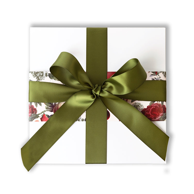 white gift box with red and green floral patterned sleeve and a green ribbon