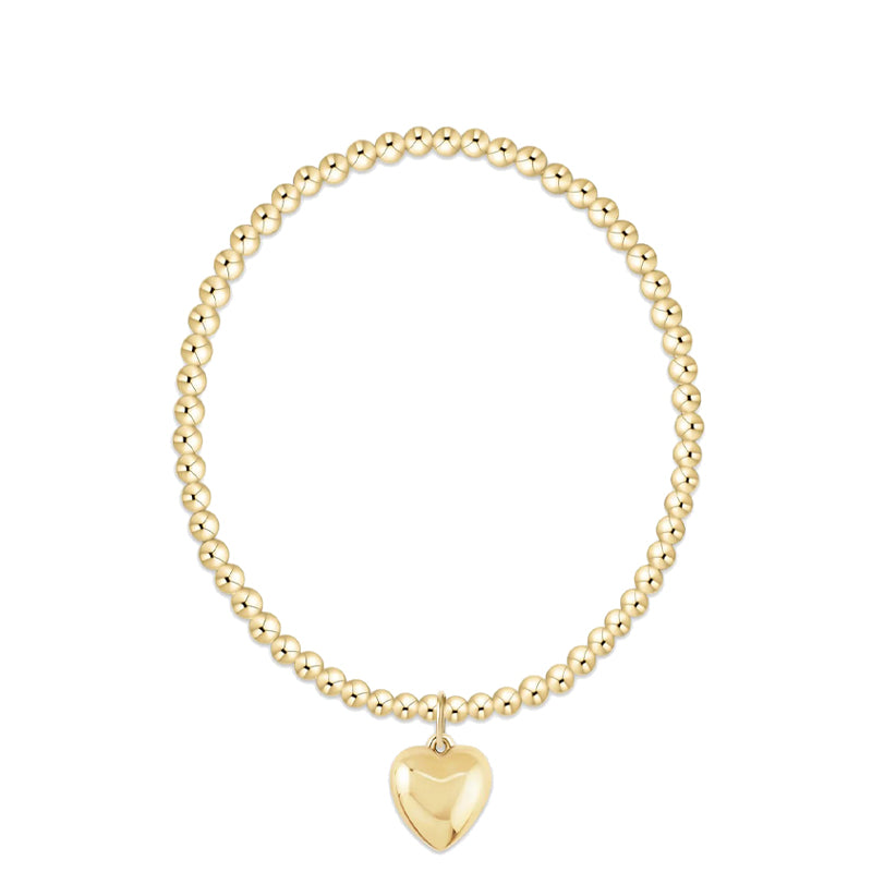 Gold beaded bracelet with a heart-shaped pendant on a white background