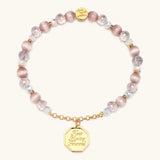 Keep Moving Forward charm bracelet with pink beads and a gold medallion
