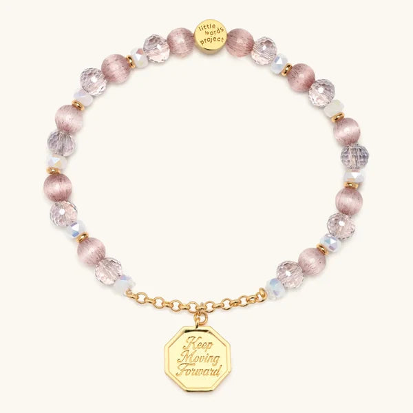 Keep Moving Forward charm bracelet with pink beads and a gold medallion