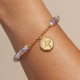 Keep Moving Forward charm bracelet worn on a wrist, charm turned to the back